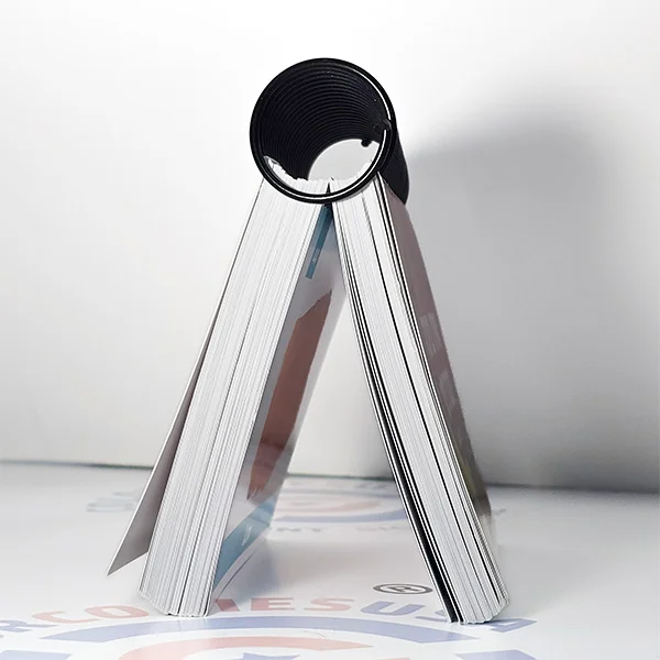 Close-up of a plastic spiral coil inserted into punched paper with a large coil