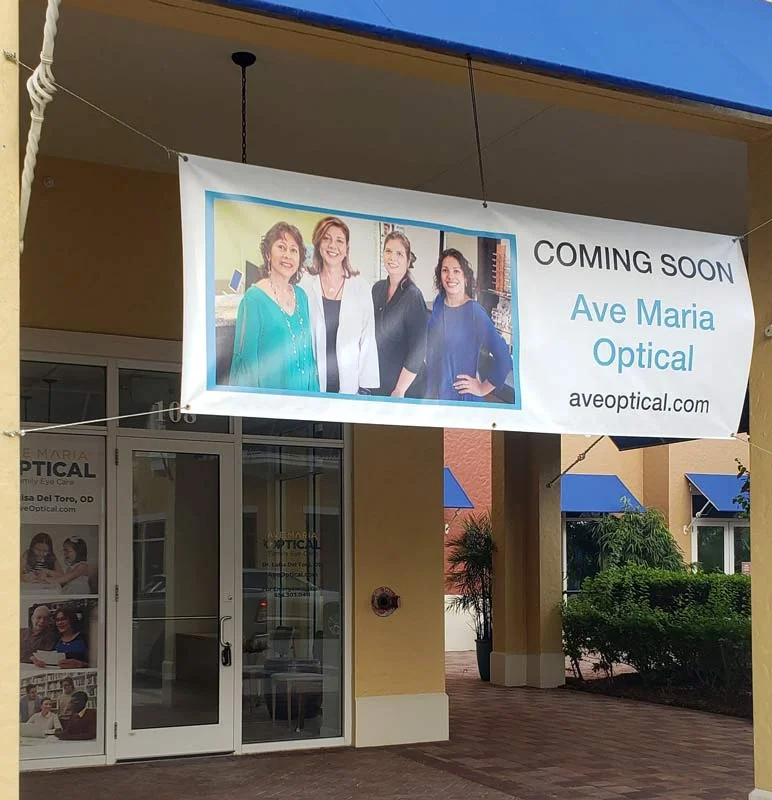 Coming Soon banner and window vinyl printed and installed by ColorCopiesUSA for Ave Maria Optical Ave Maria Optical storefront with a Coming Soon vinyl banner and window vinyl graphics printed and installed by ColorCopiesUSA