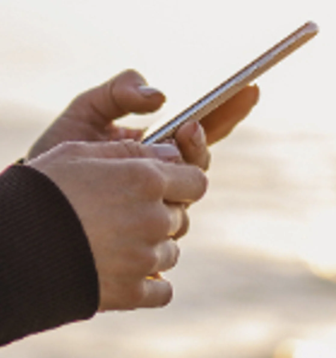 Low resolution image example showing blurry pixelated details on a hand holding a phone